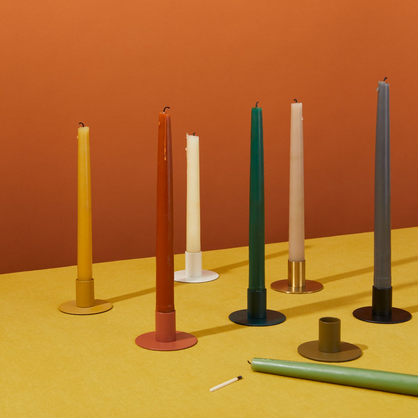 Group of taper candles in holders.