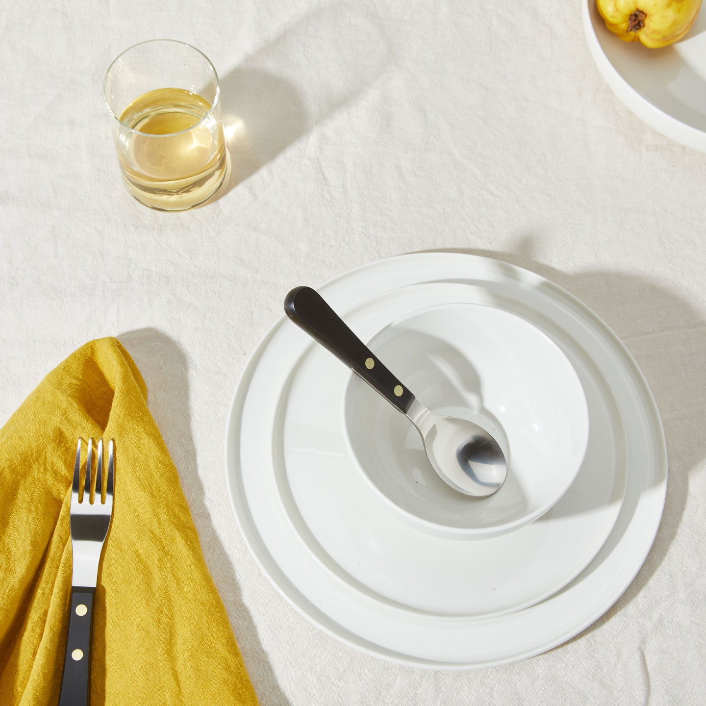 Table setting with Simple Porcelain Dinnerware, Simple Glassware, Simple Linen Napkins, and Provencal Flatware.