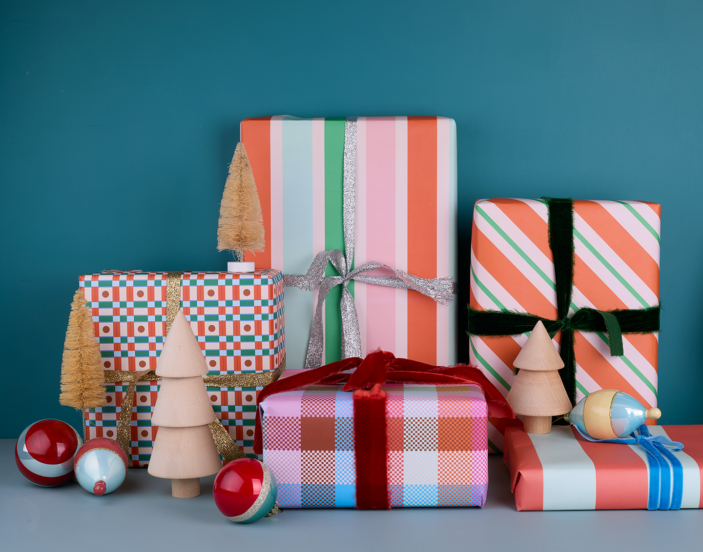 Various wrapped packages with wooden trees, bottlebrush trees, and glass ornaments