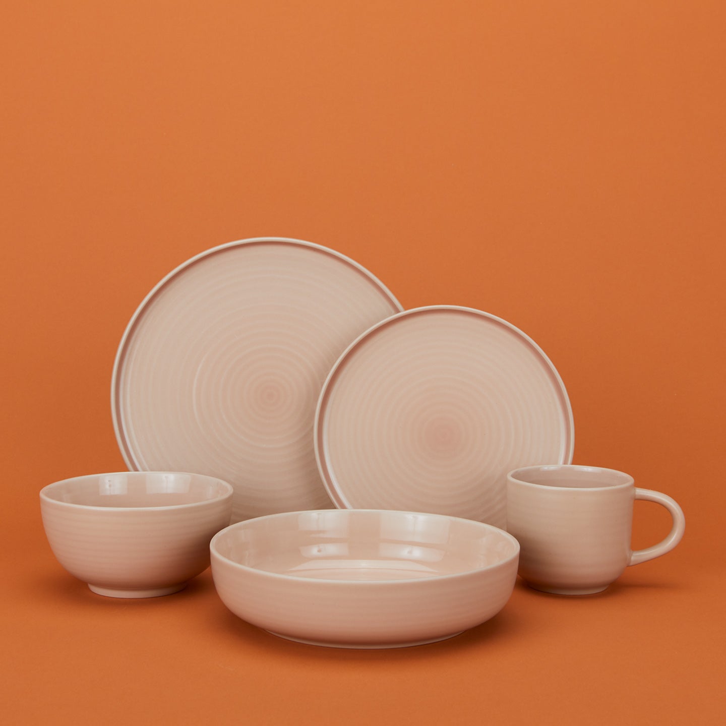 Group of Essential Dinnerware in Blush including low bowl, large bowl, salad plate, dinner plate and mug.