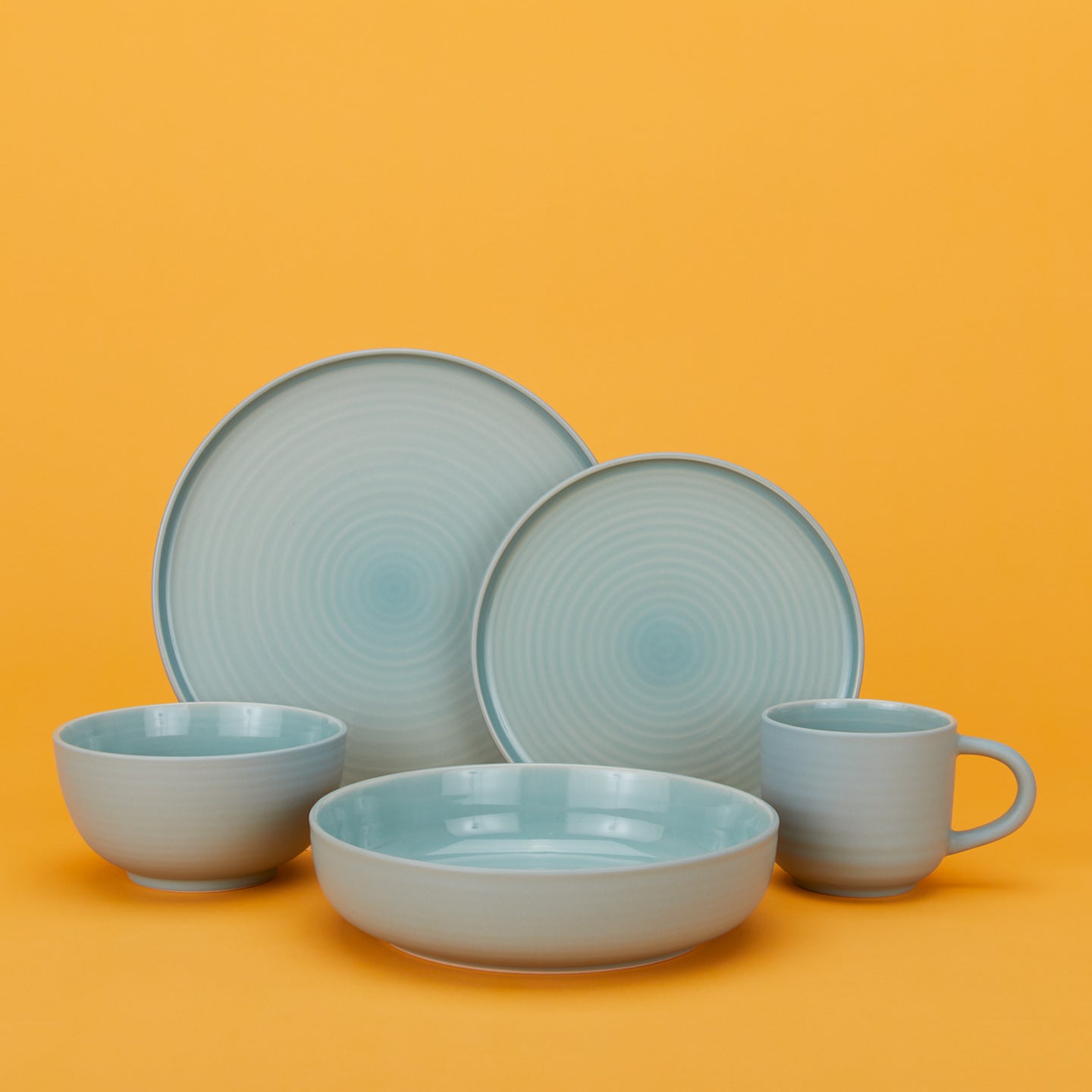 Group of Essential Dinnerware in Sky including low bowl, large bowl, salad plate, dinner plate and mug.