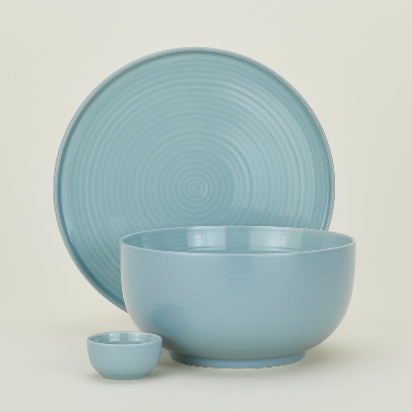 Group of Essential serving pieces in Sky including bowl, platter and extra small bowl.