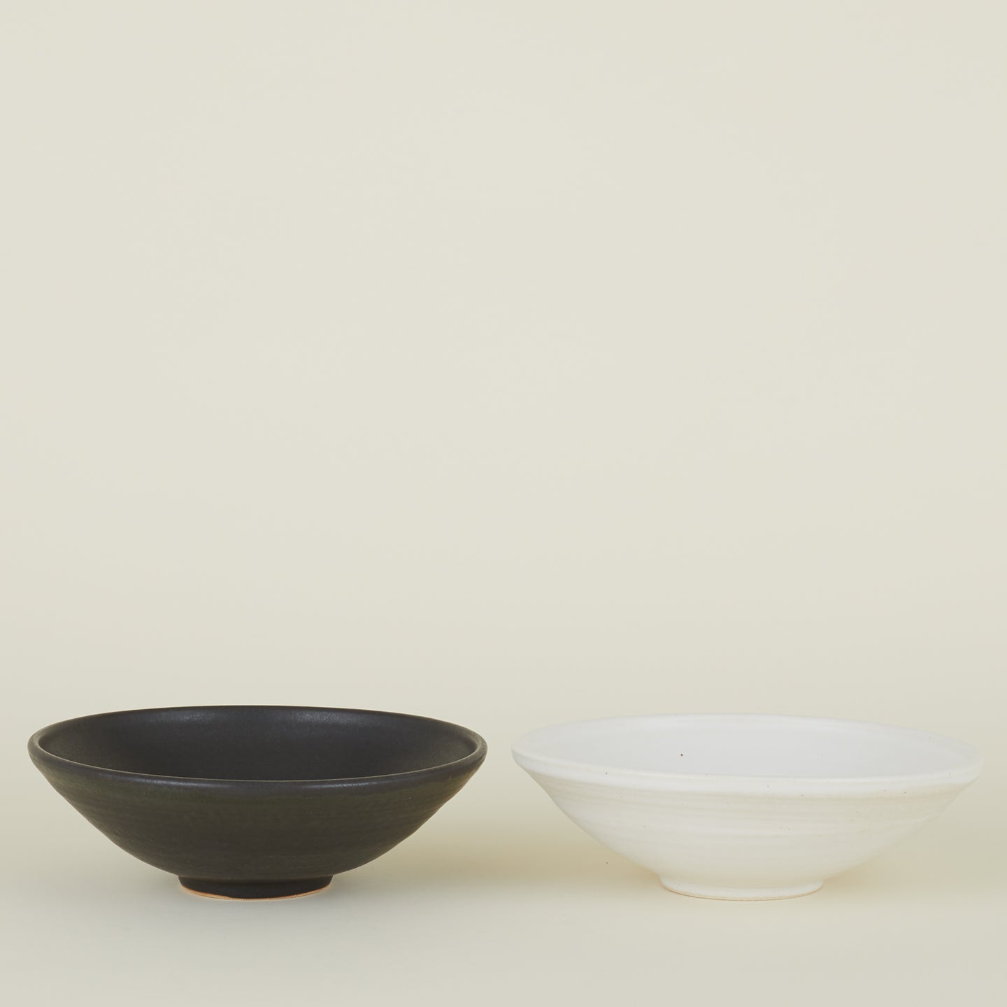 Two Stoneware Flared Bowls, one in Black and one in Eggshell.