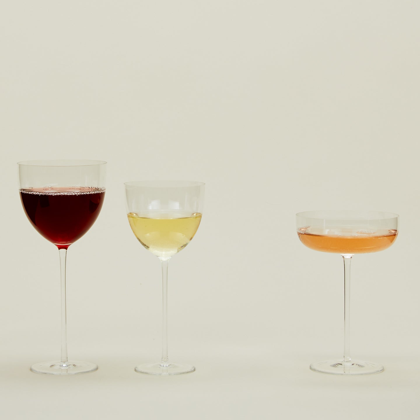 Group of three Crystalline Glasses in various shapes, filled with liquid.