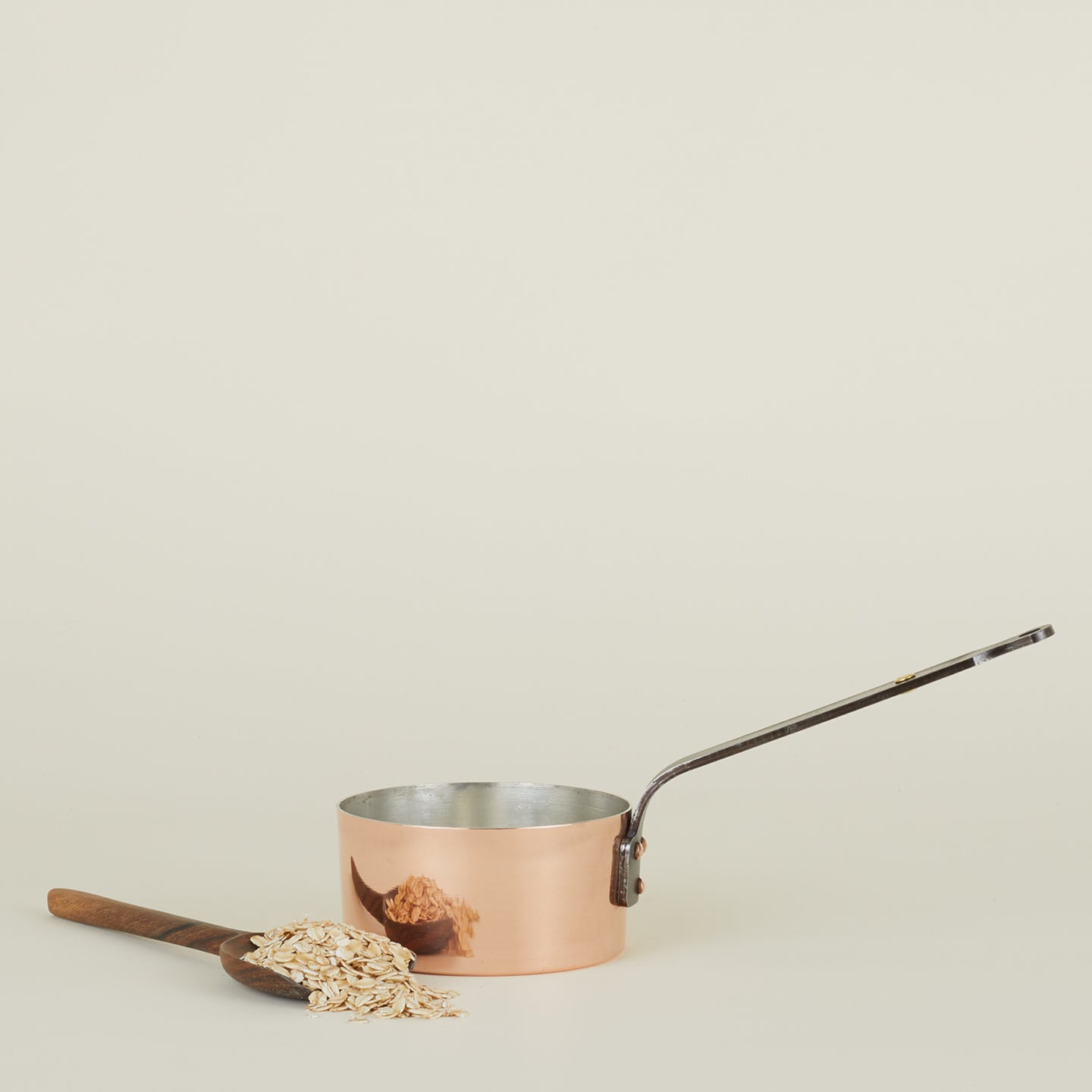 Copper saucepan with scoop and oats