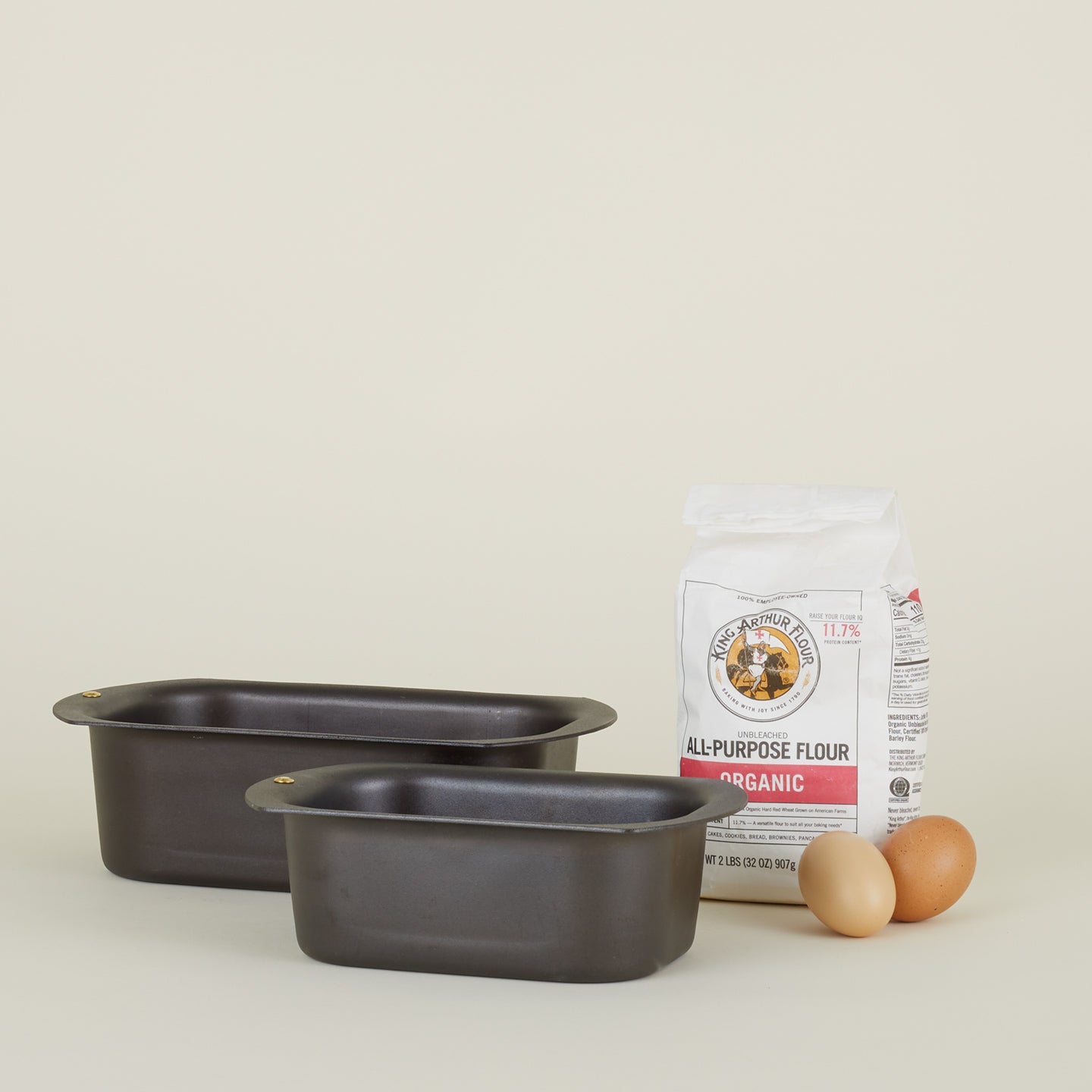 Large and small spun iron loaf pans with flour and eggs