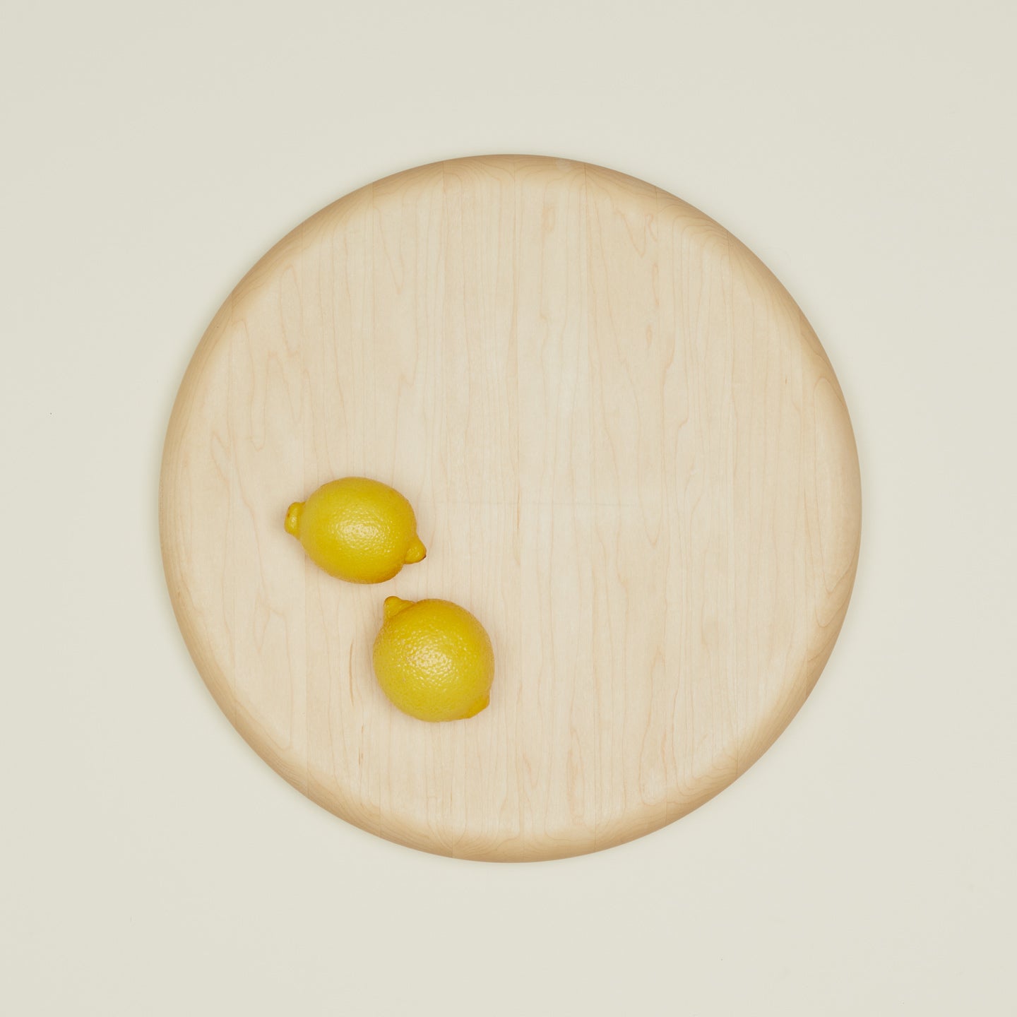 Overhead of simple wood chopping block with two lemons