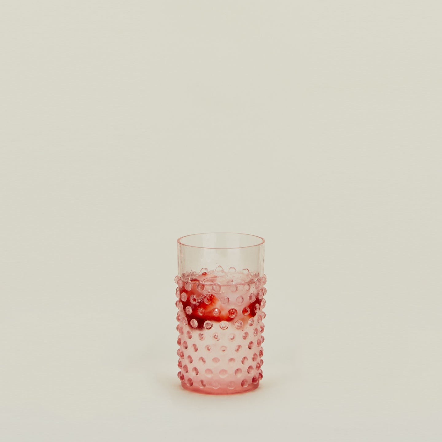 Hobnail Tumbler in Blush filled with water and fruit.