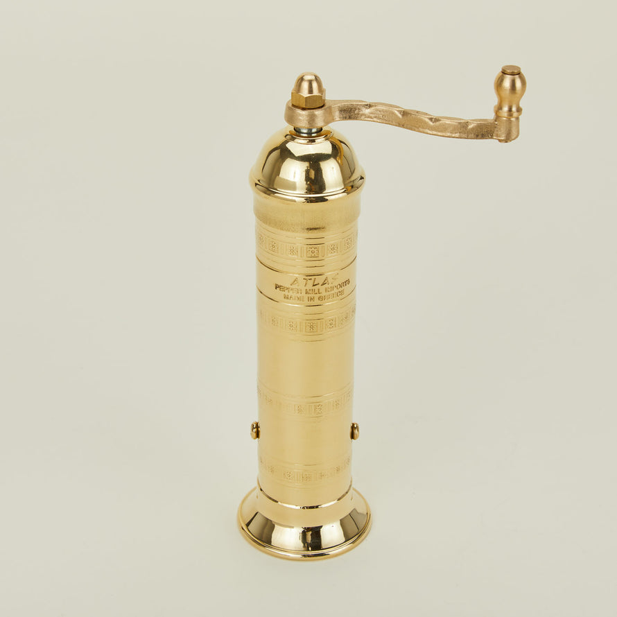 A close up of a brass pepper mill.