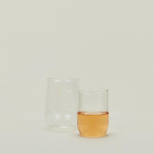 Two clear Boreal Tumblers in various sizes, one filled with sparkling wine.