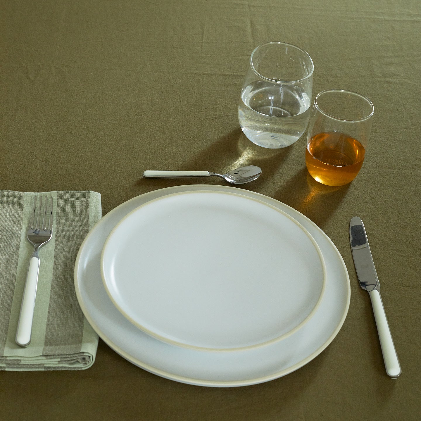 Placesetting with Boreal Tumblers on a green tablecloth.