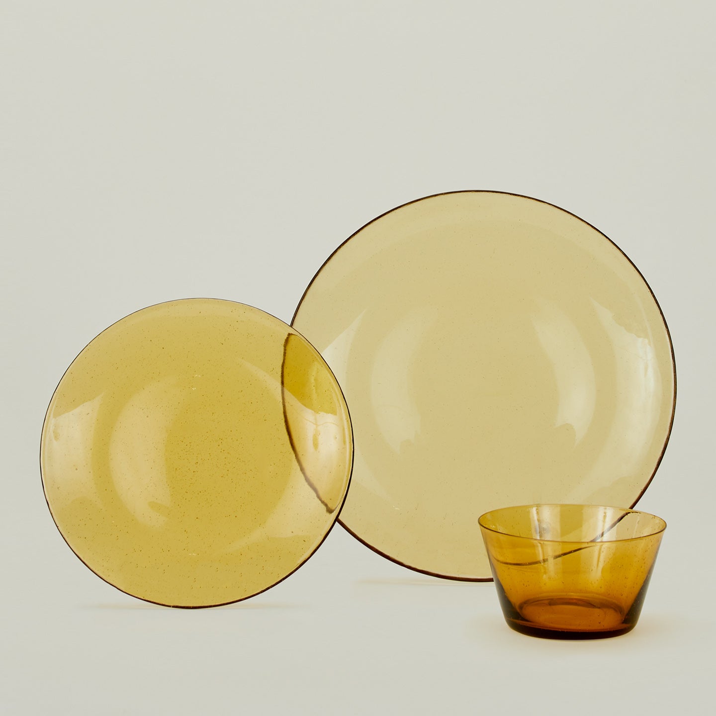 Group of Amber glass salad plate, dinner plate and bowl.