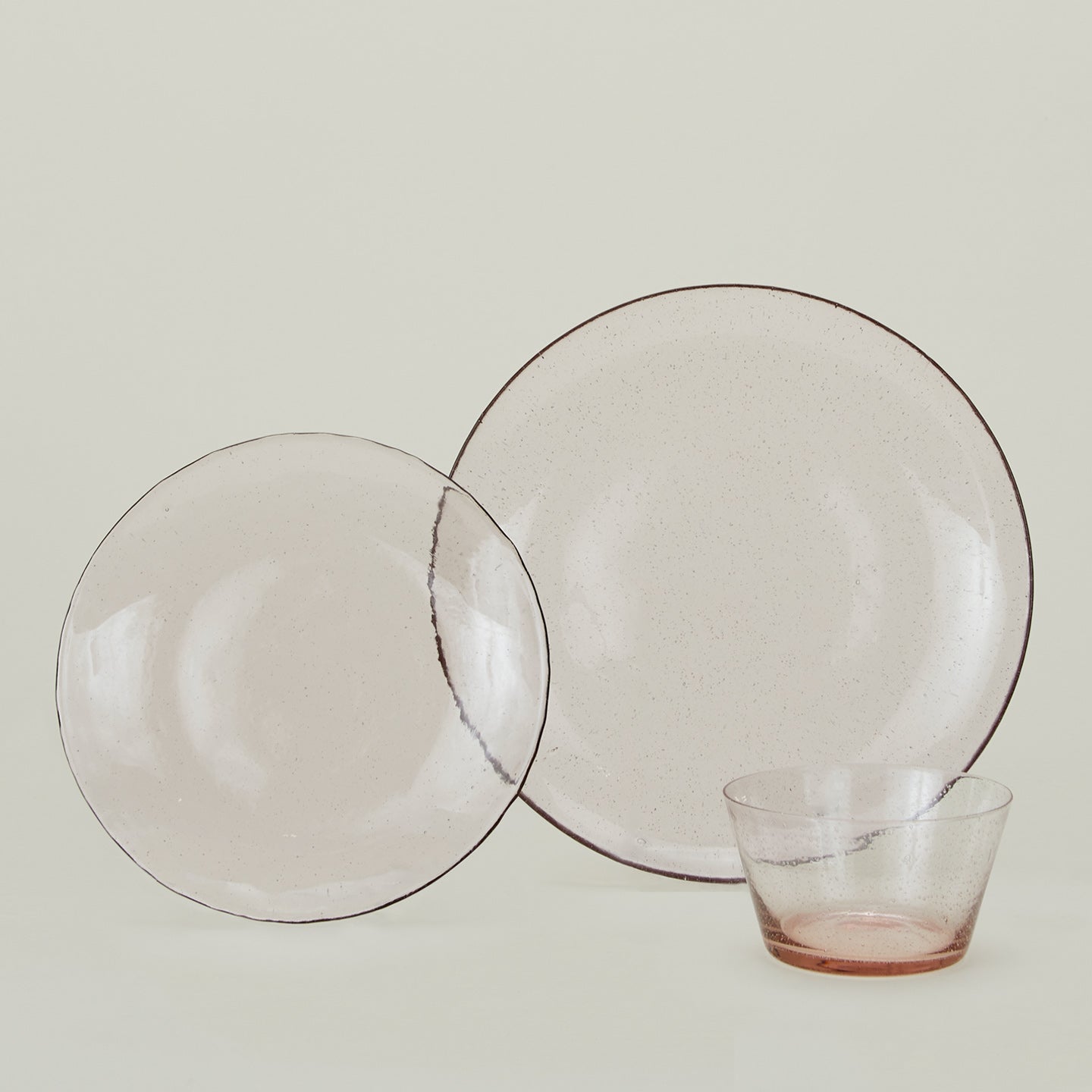 Group of Blush glass salad plate, dinner plate and bowl.