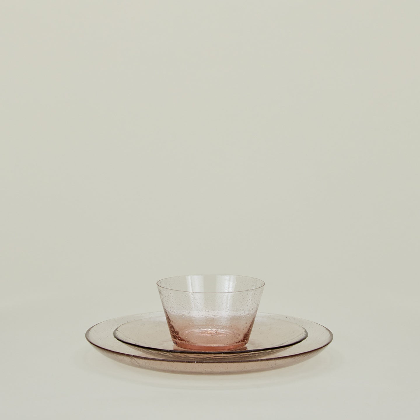 Group of Blush glass salad plate, dinner plate and bowl.