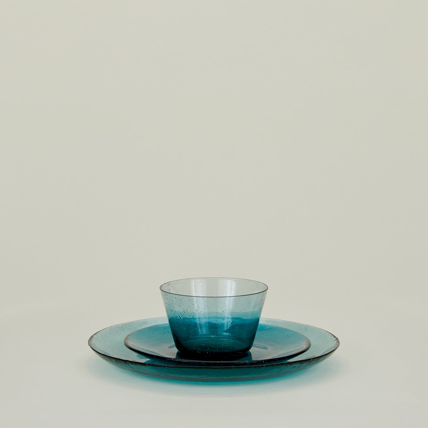 Group of Peacock glass salad plate, dinner plate and bowl, stacked.