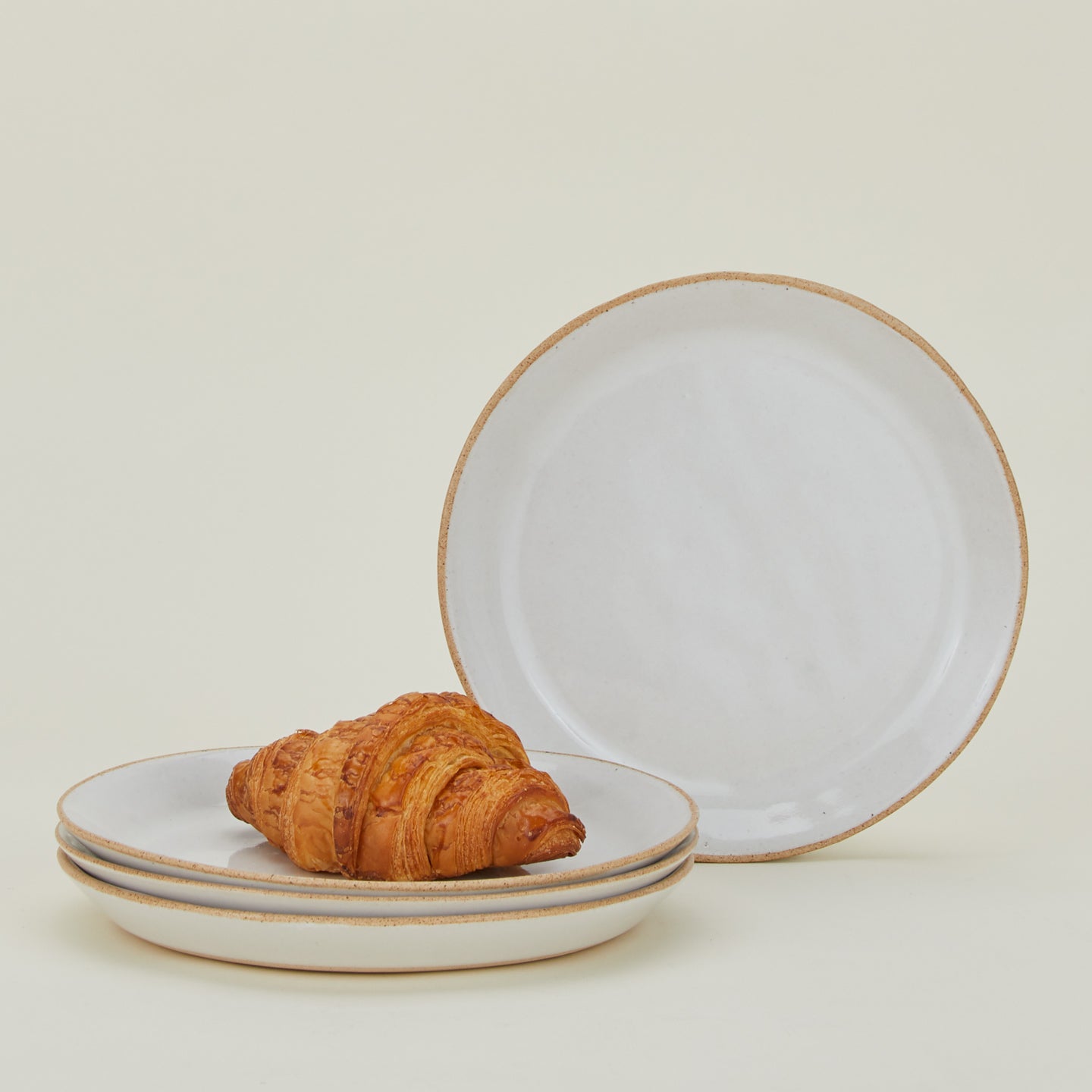 Four Minimal Dinner Plates with croissant.