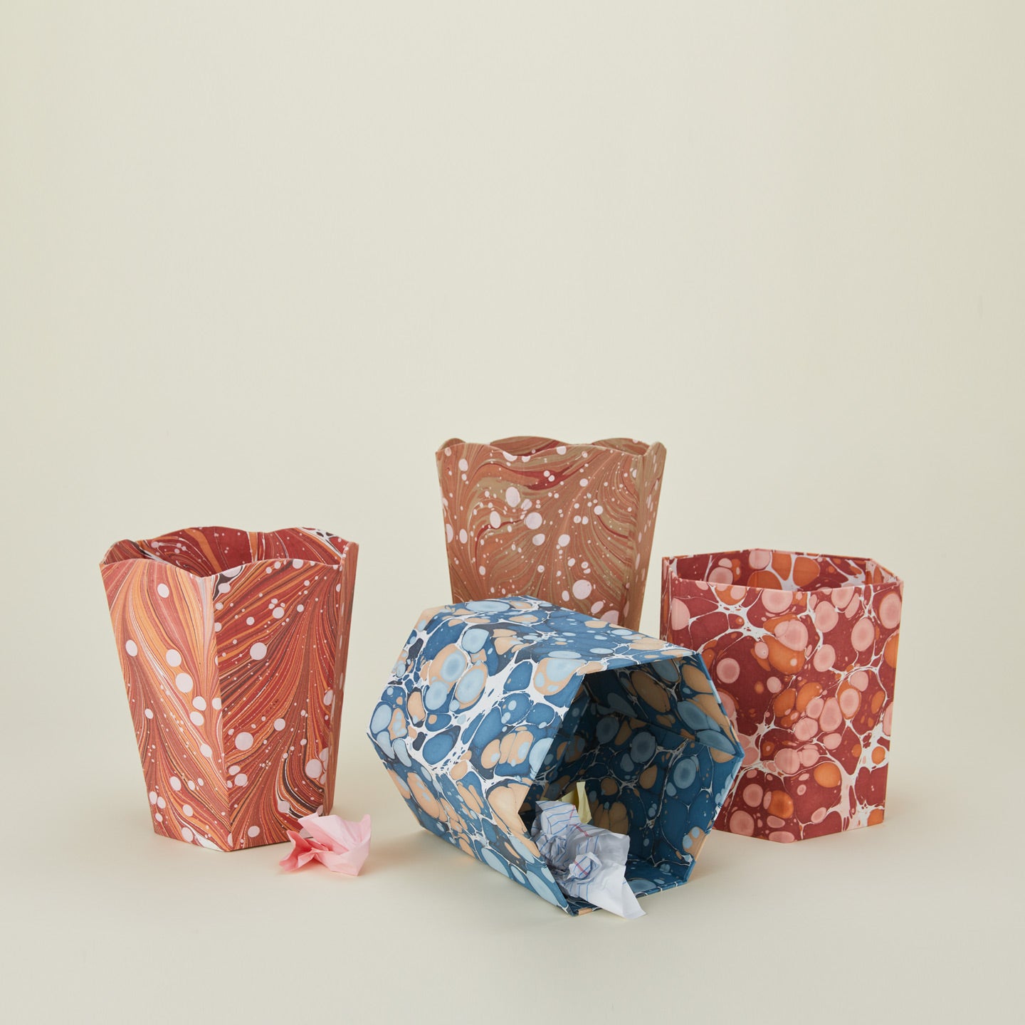 Marbled wastebaskets in various shapes and colors.