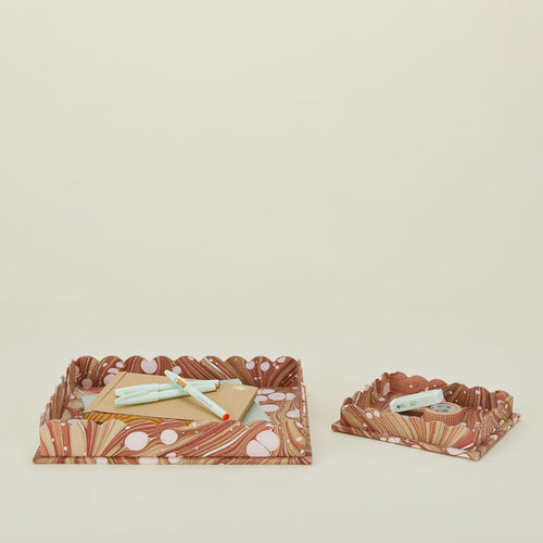 Set of two scalloped marbled trays in mocha with office supplies.