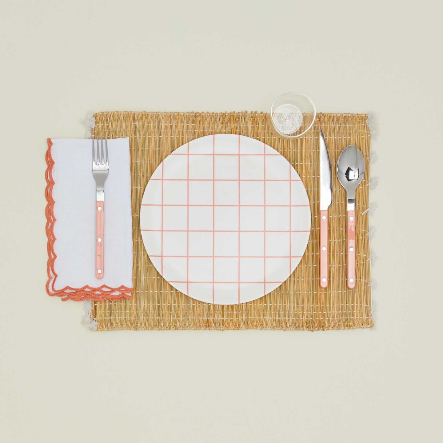 Place setting with a napkin with a scalloped edge in orange.