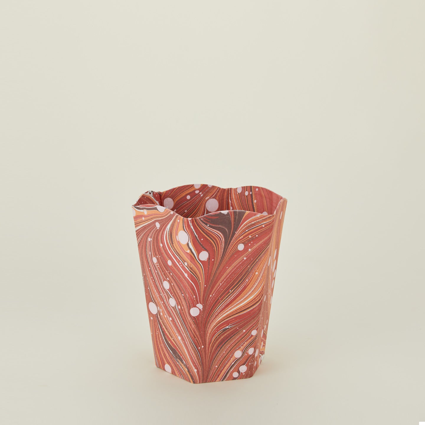 Marbled scalloped wastebasket in red.