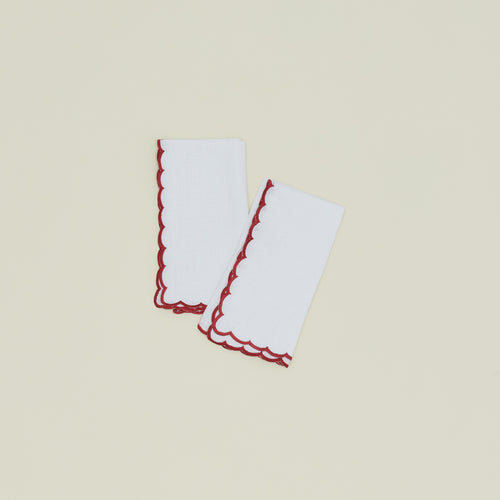 A set of two napkins with a scalloped edge in red.