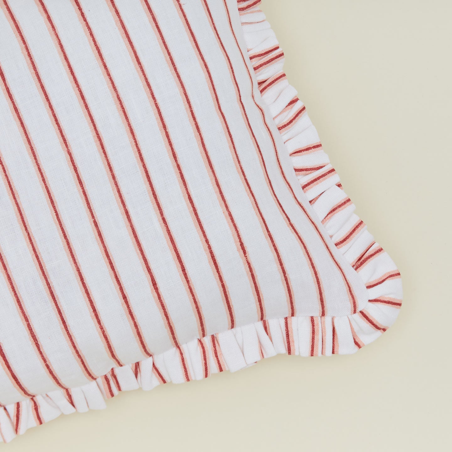 Detail of block printed striped ruffled pillow in Red.