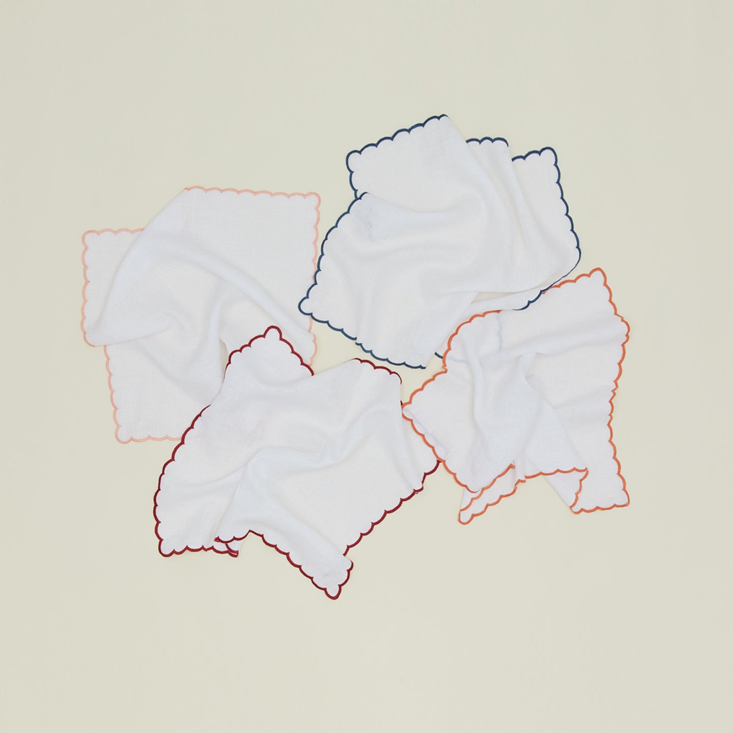 Unfolded napkins with scalloped edges in various colors.