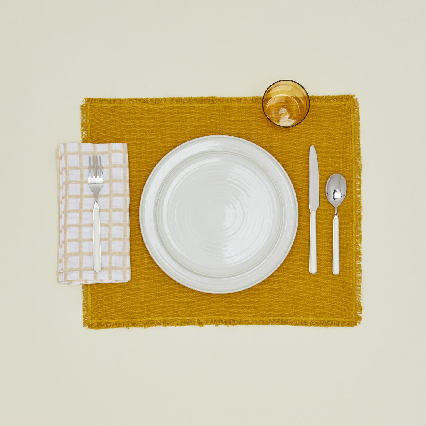 Place setting with block printed napkin in tan.