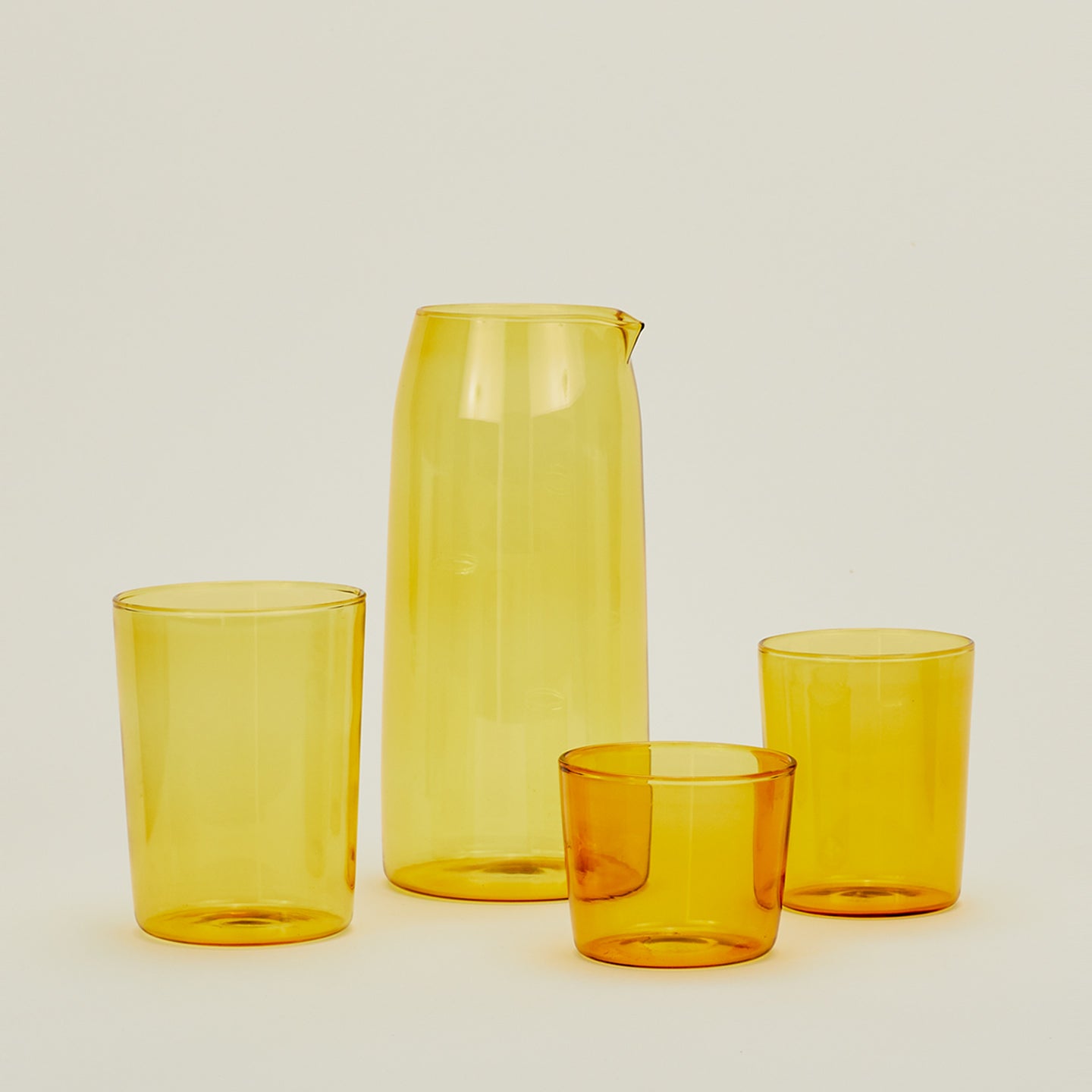 Small, Medium and Large Essential Glasses with Essential Glassware Pitcher in Amber.