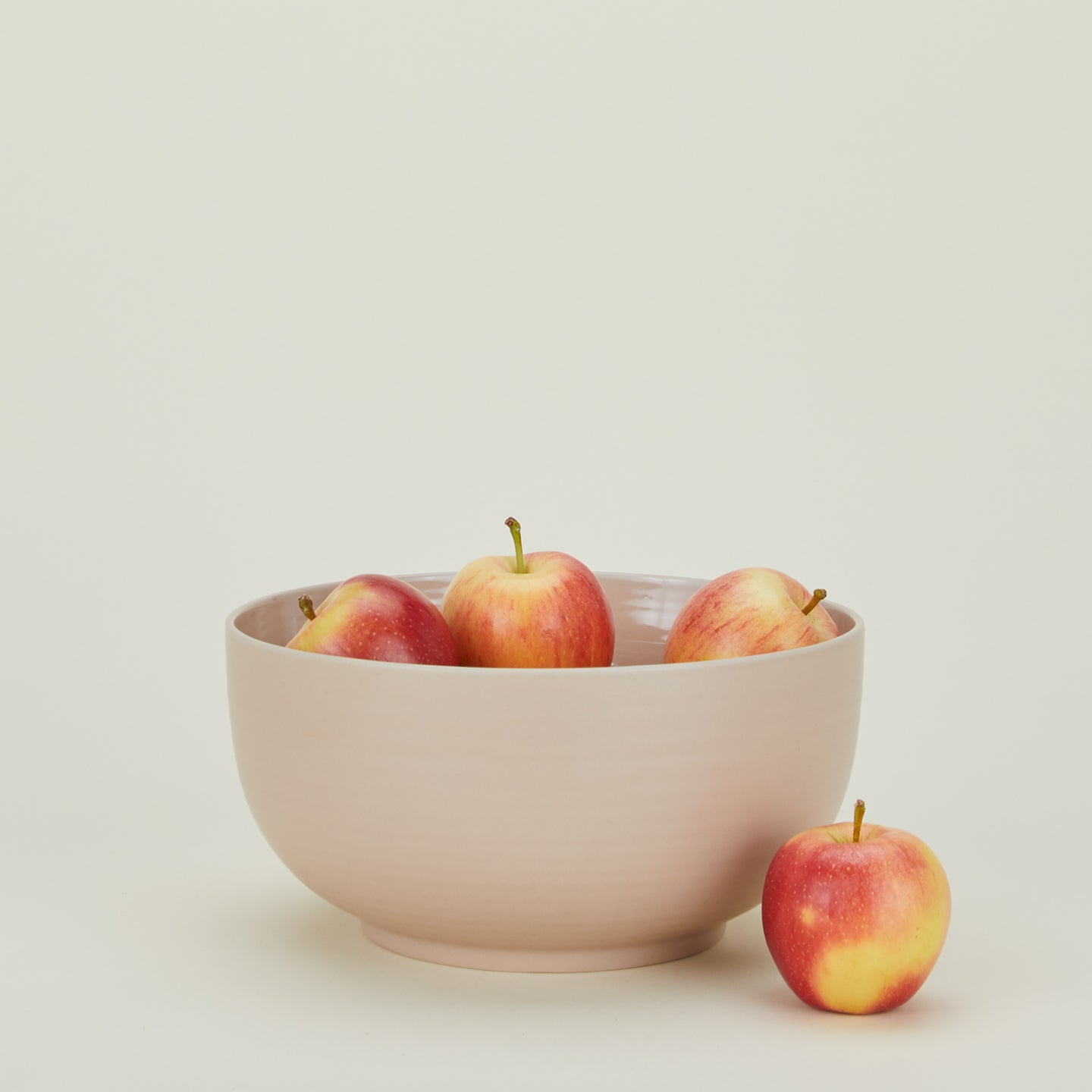 Essential Serving Bowl in Blush with apples.