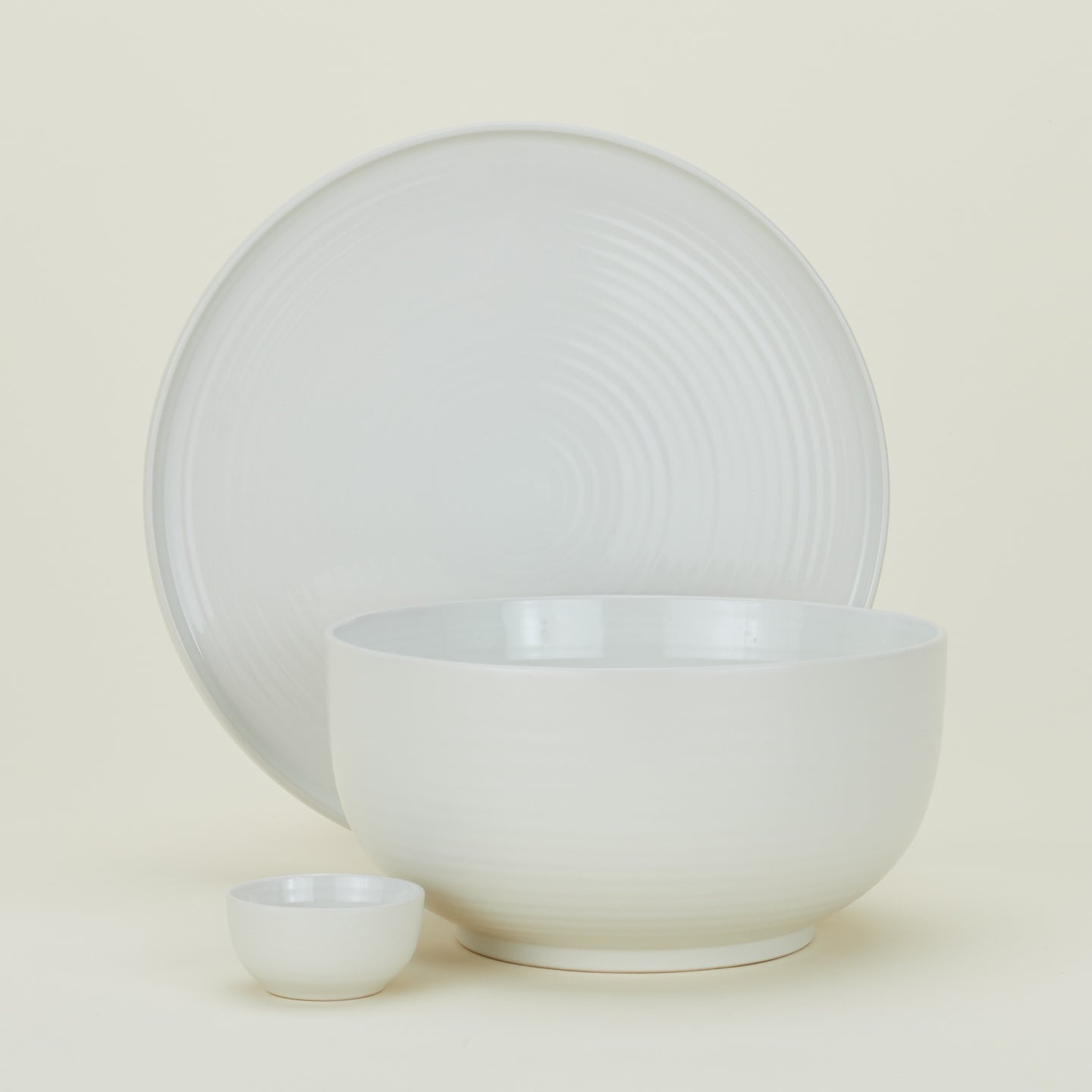 Group of Essential serving pieces in Bone including bowl, platter and extra small bowl.