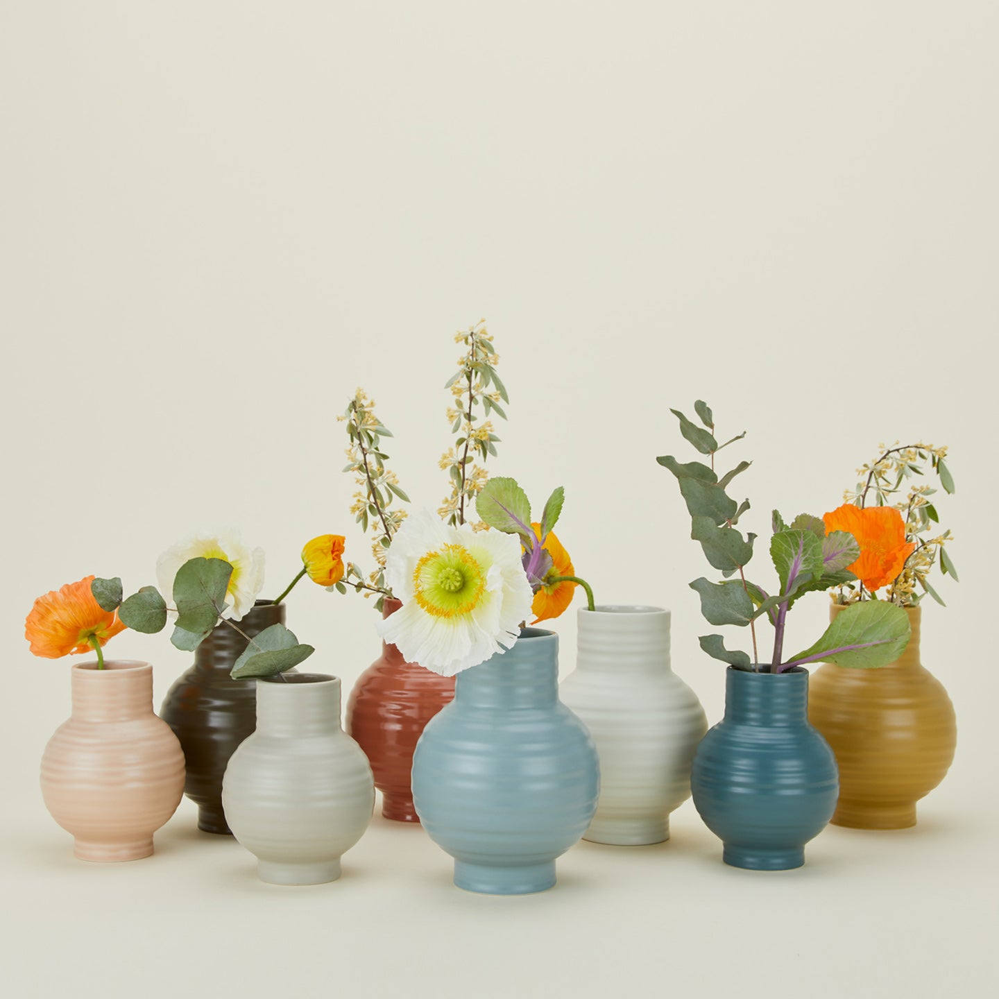 Essential ceramic vases in various colors with flowers