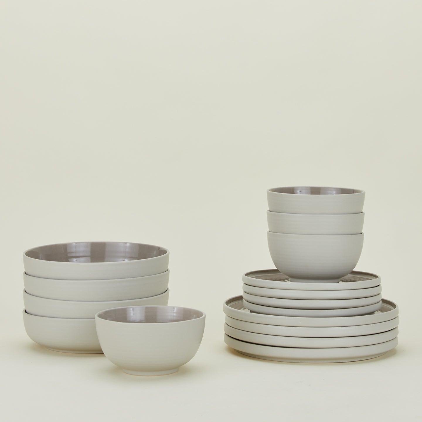 Set of light grey Essential dinnerware including Large Bowls, Low Bowls, Salad Plates and Dinner Plates.