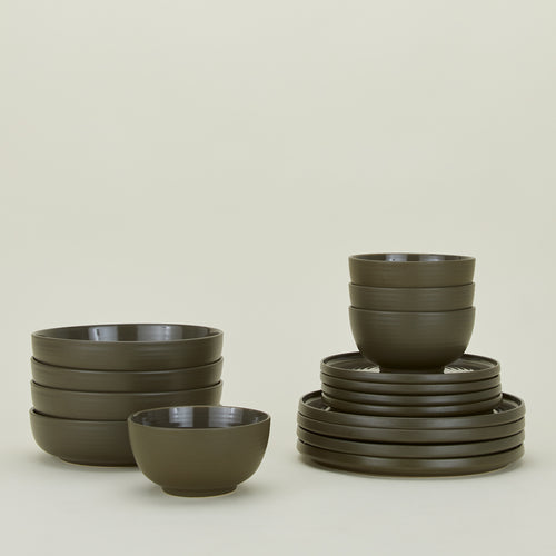 Set of olive green Essential dinnerware including Large Bowls, Low Bowls, Salad Plates and Dinner Plates.