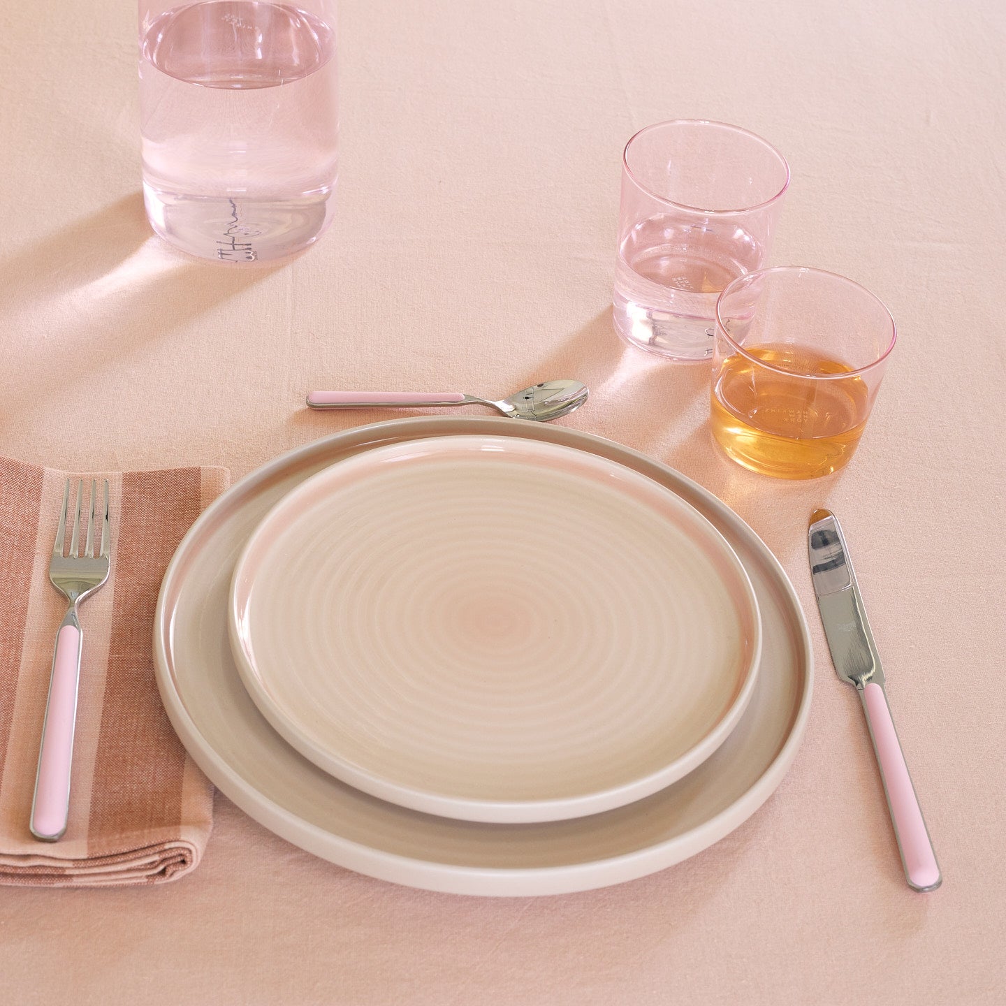 Placesetting with Essential Glassware in Blush on pink tablecloth.
