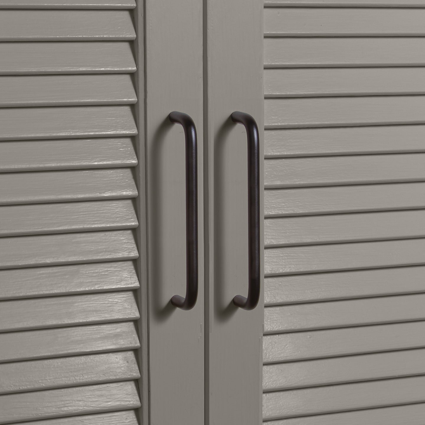 Large black pulls on louvered doors