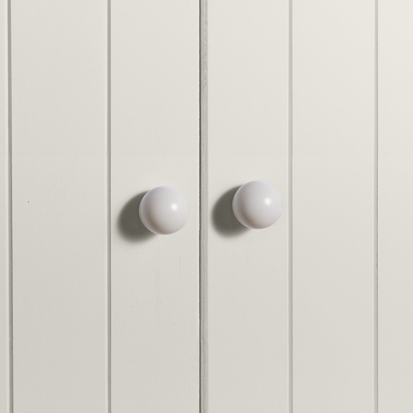 Large ivory essential sphere knobs on white doors