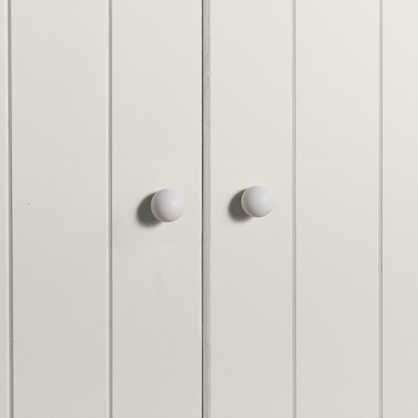 Small ivory essential sphere knobs on white doors