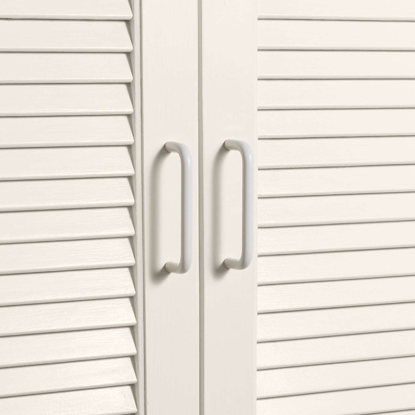 Small ivory pulls on louvered doors