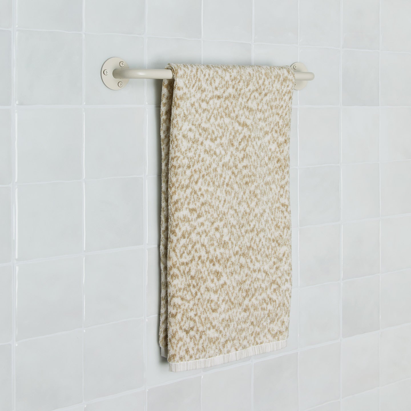 Essential towel bar in Ivory with Space Dye terry hand towel in Flax on tiled wall.