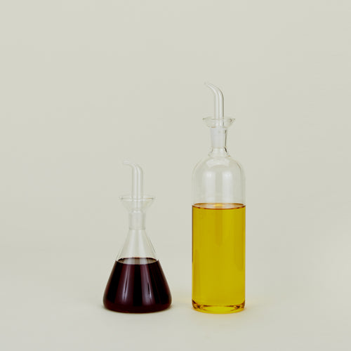 Set of two glass bottles one filled with vinegar one filled with oil