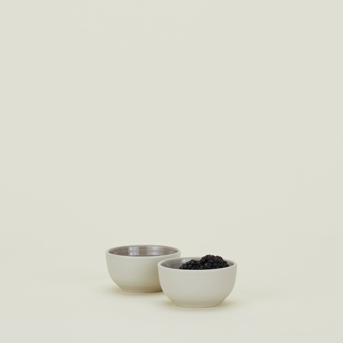 Two Essential Extra Small Bowls in Light Grey filled with blackberries.