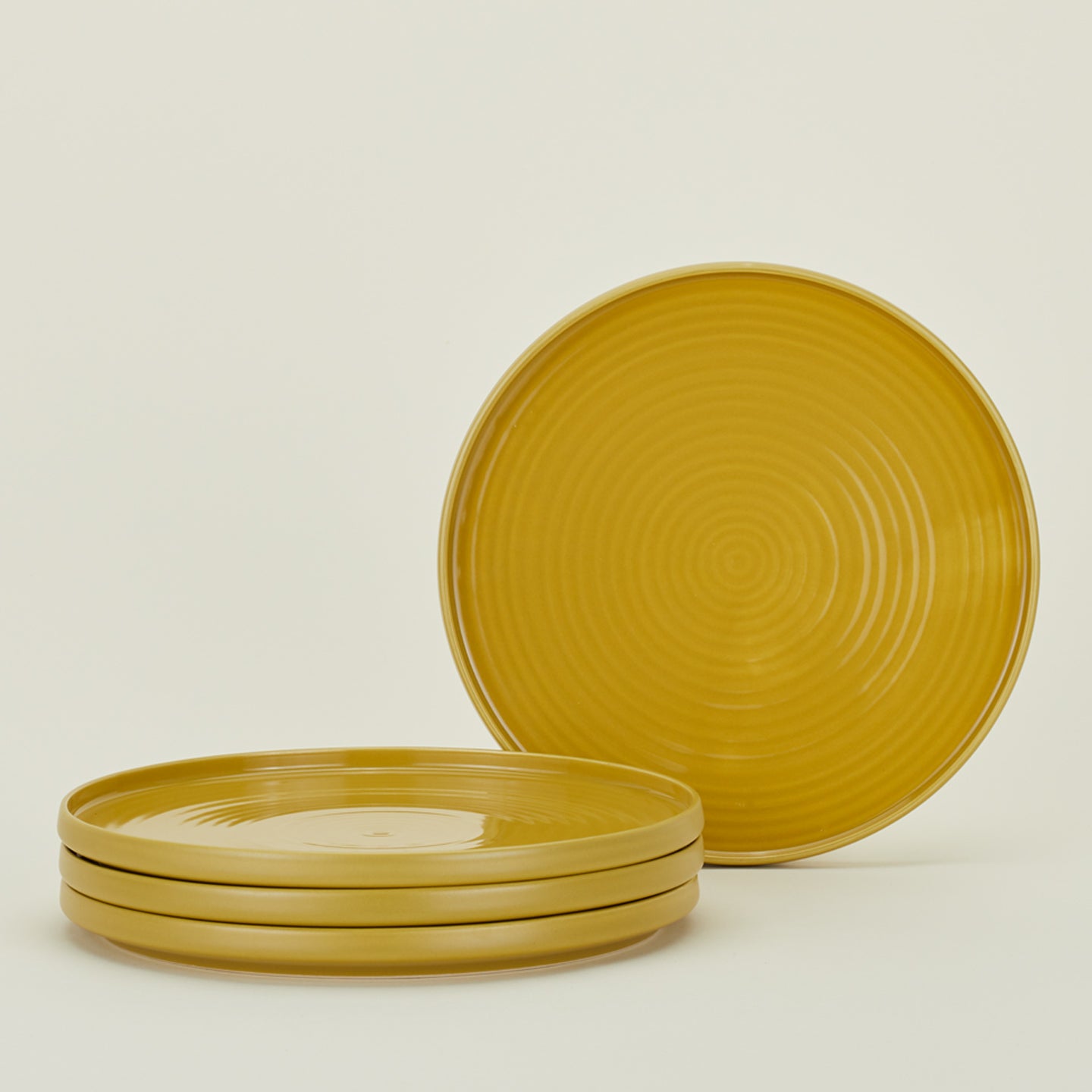 Four mustard yellow Essential Dinner Plates.