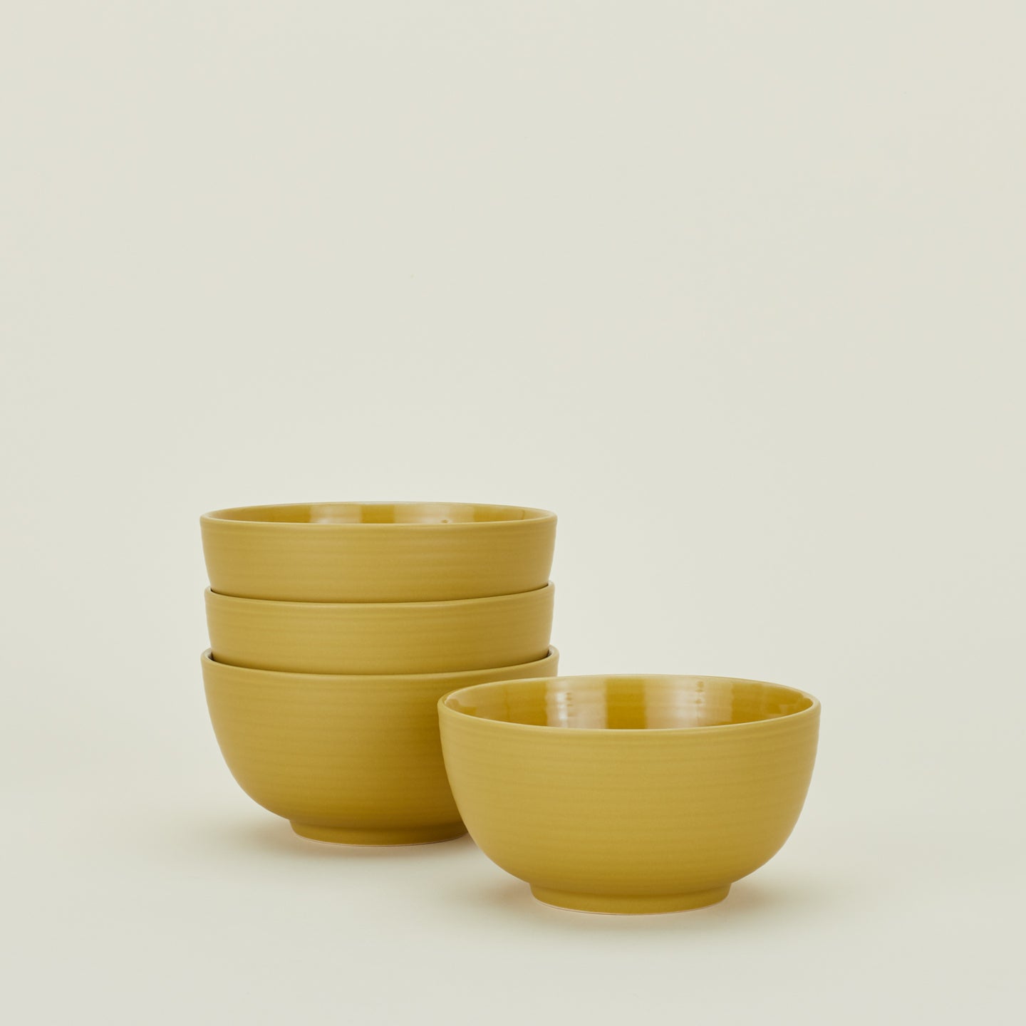 Four mustard yellow Essential Large Bowls.