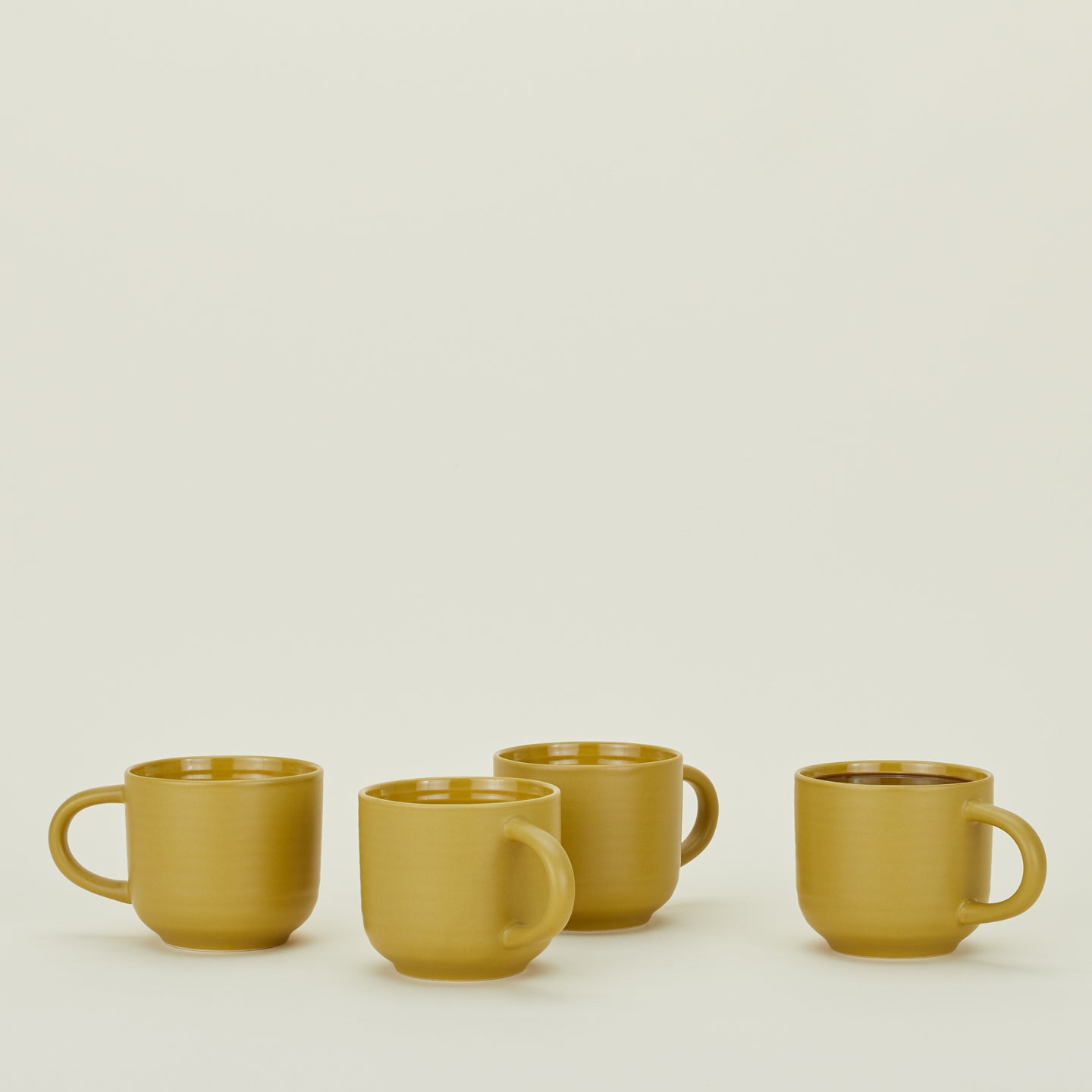 Four Essential Mugs in Mustard, with coffee.