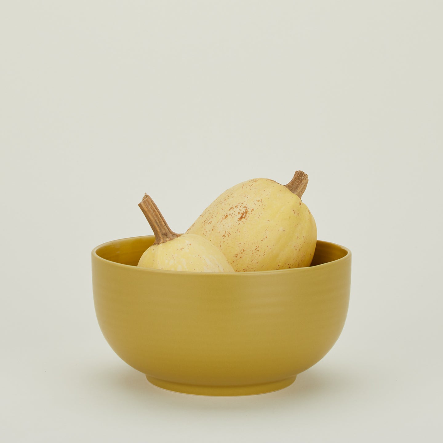 Essential Serving Bowl in Mustard with squash.