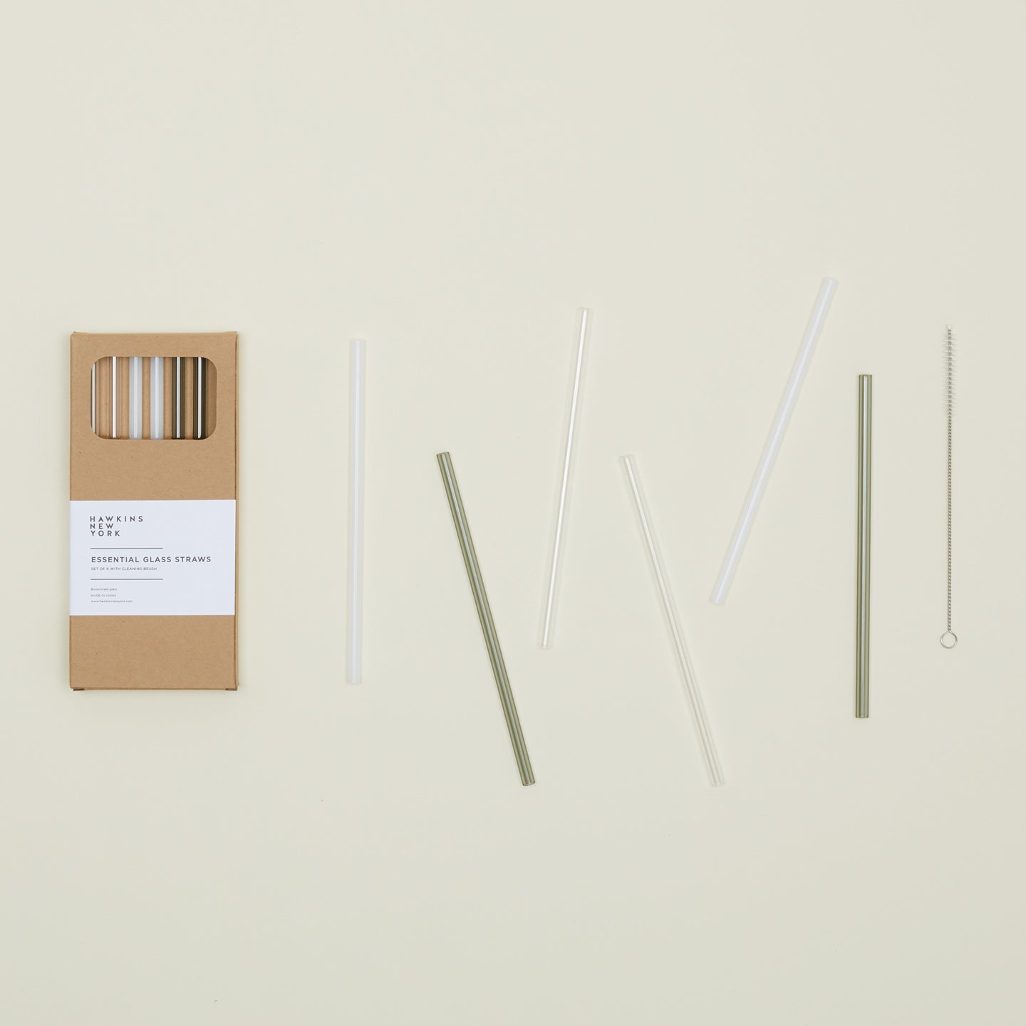 Kraft colored gift box of Essential Glass Straws in Neutral, with straws scattered nearby.