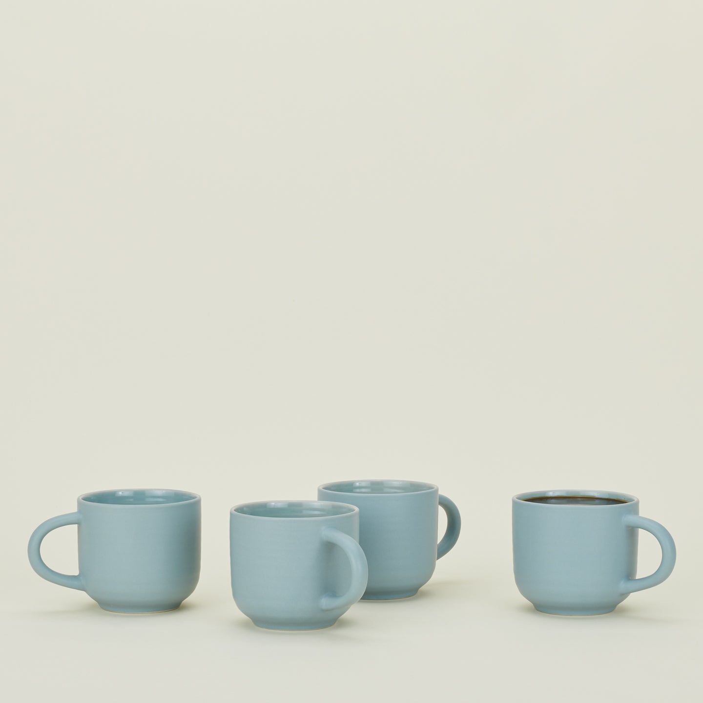 Four Essential Mugs in Sky, with coffee.