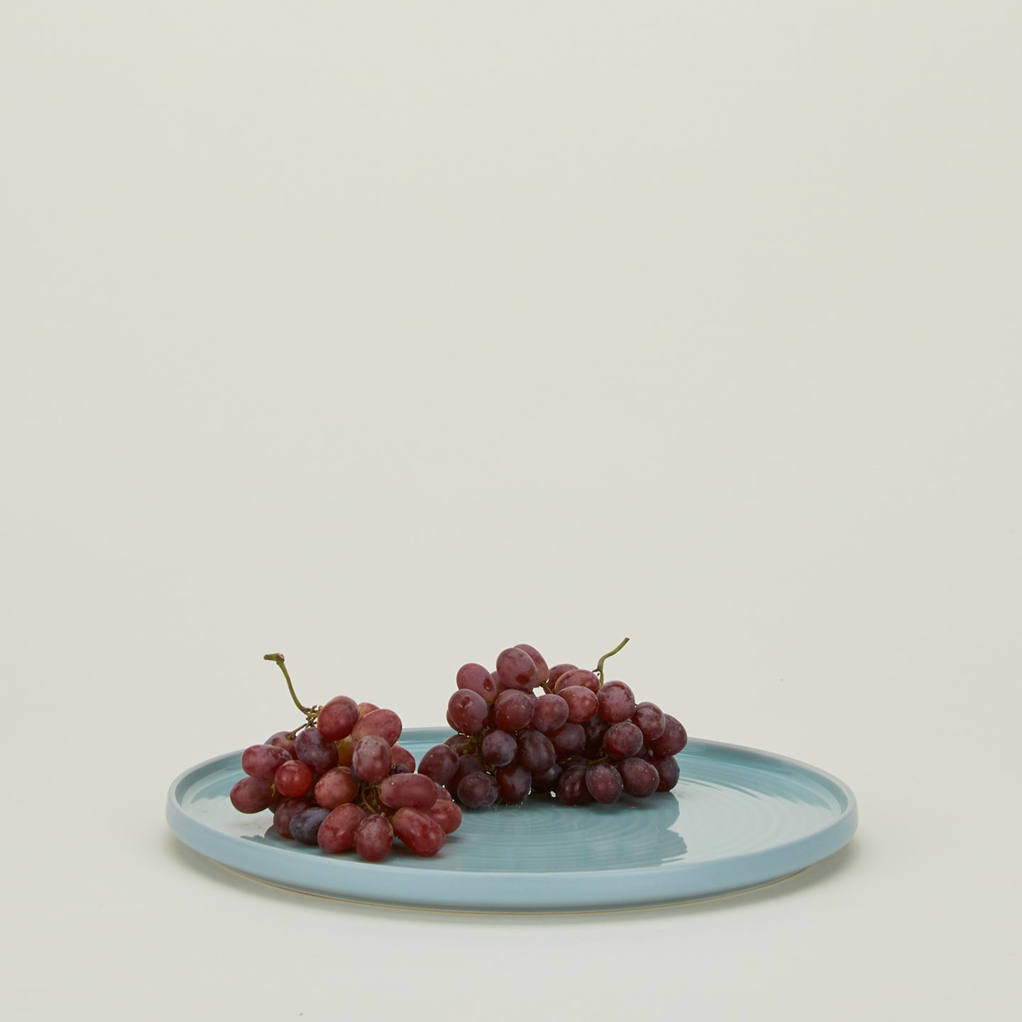 Essential Serving Platter in Sky with grapes.