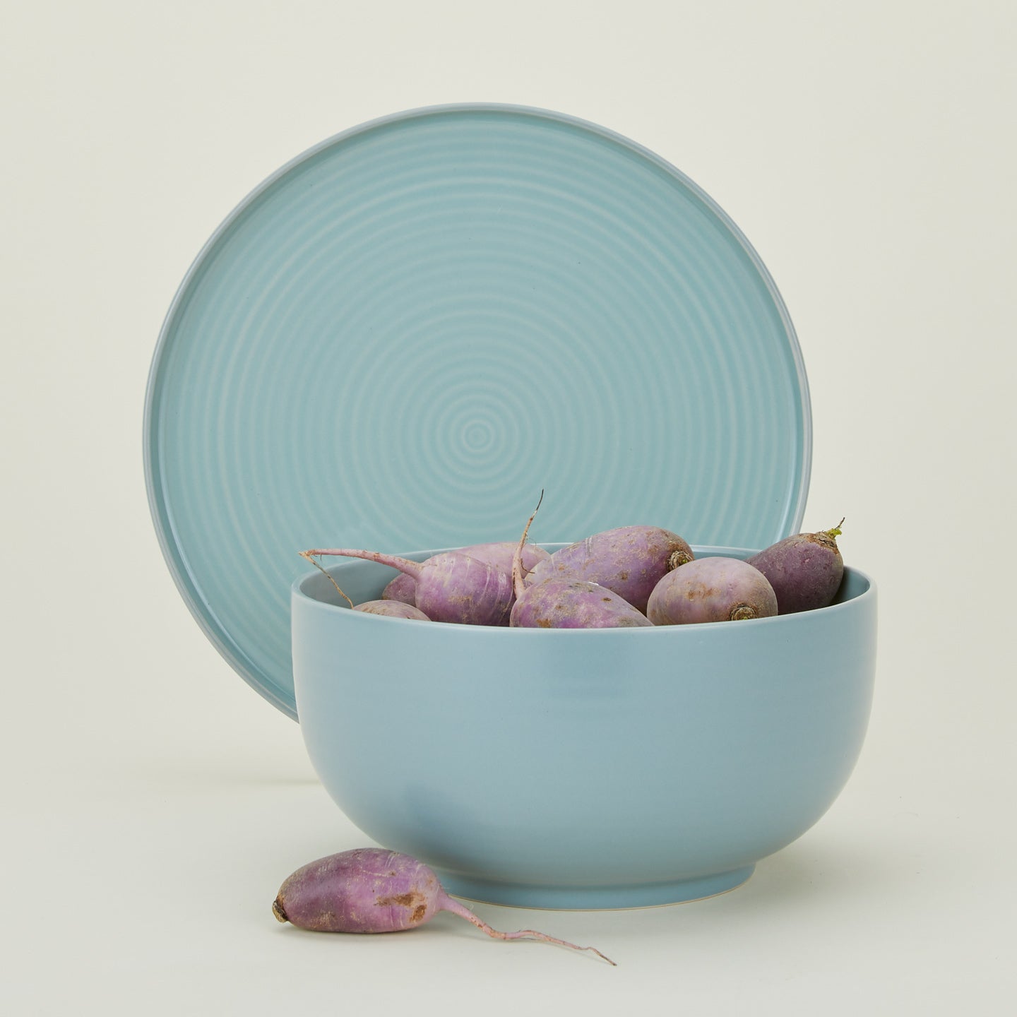 Essential Serving Bowl and Serving Platter in Sky, with root vegetables.